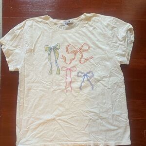 Anthropologie Cream Tee with Whimsical Bow Design